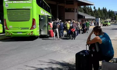 Personas esperando colectivos en estación.