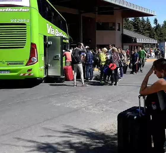 Personas esperando colectivos en estación.