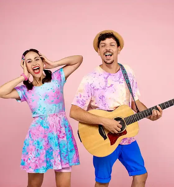 Pareja con ropa colorida y guitarra. Pequeño Pez regresa a los escenarios