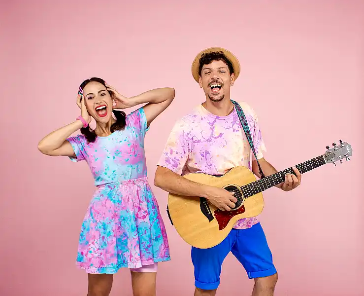 Pareja con ropa colorida y guitarra. Pequeño Pez regresa a los escenarios