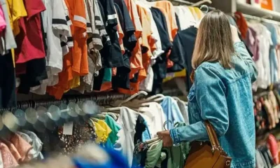 Mujer eligiendo ropa en tienda de ventas PyME