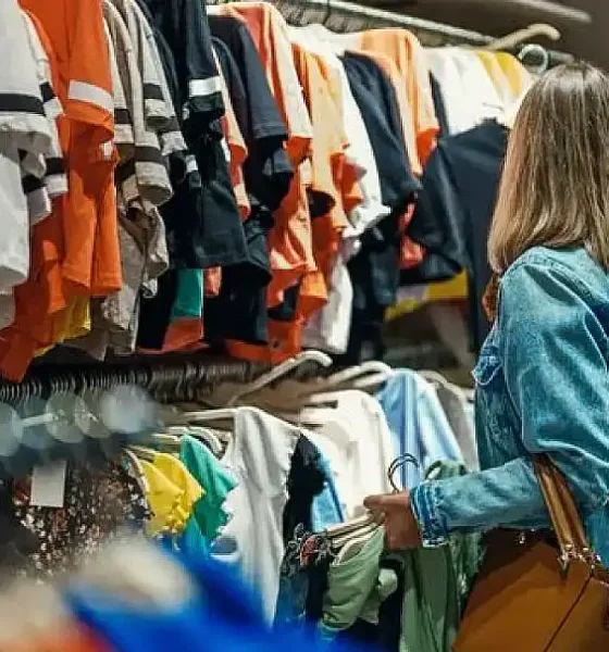 Mujer eligiendo ropa en tienda de ventas PyME